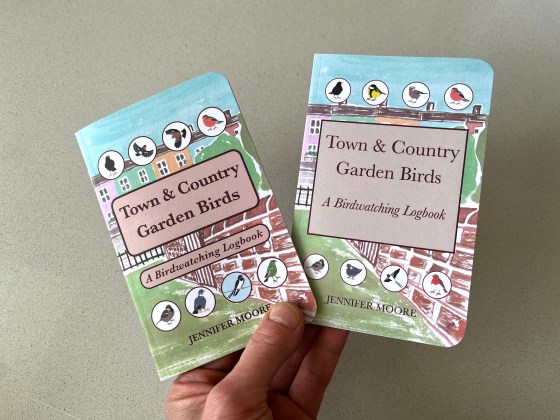 2 birdwatching logbooks held in hand