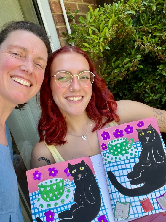 Author and daughter with artworks of a black cat
