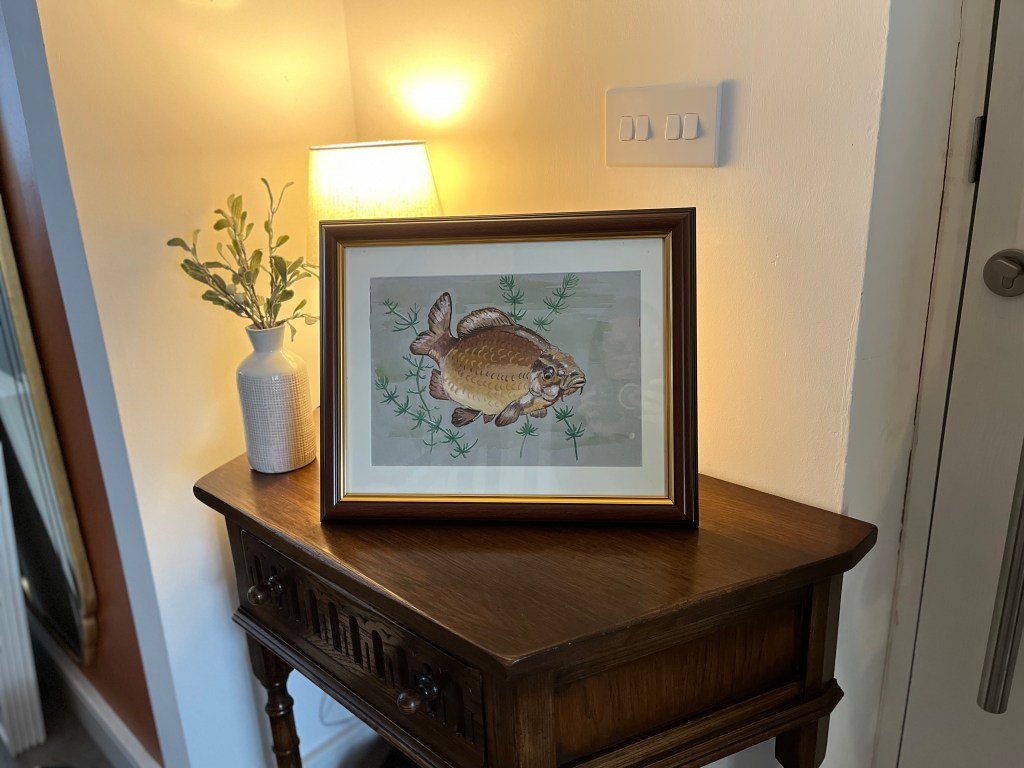 framed painting of a fish in a cosy hallway
