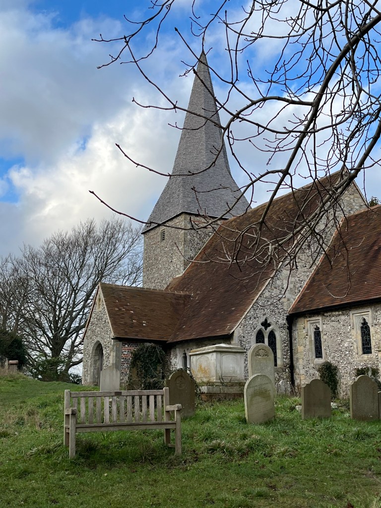 Sussex flint church with spire and graveyard